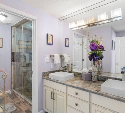 Bathroom vanity w/ large mirror, clean lines & simple coastal style.