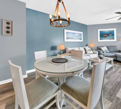 Open dining area w/ round table, soft coastal tones, & easy flow into the living space