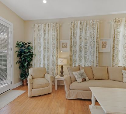 living room has 2 large sofas and a swivel chair