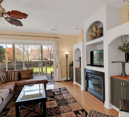 living room has sofas ,large flat screen tv plus bank of glass doors to the back