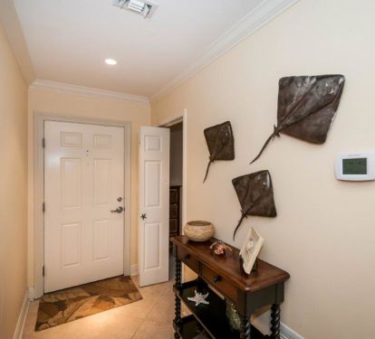 foyer of condo with bunk room on right with a door and guest room on the left 