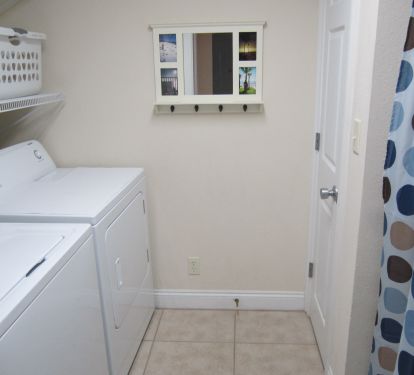 Convenient laundry room with full-size washer and dryer.