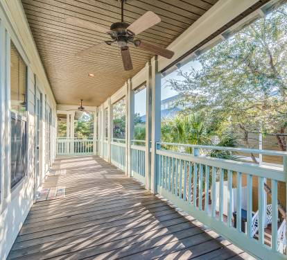 Second floor covered porch with ceiling fans and adirondack chairs
