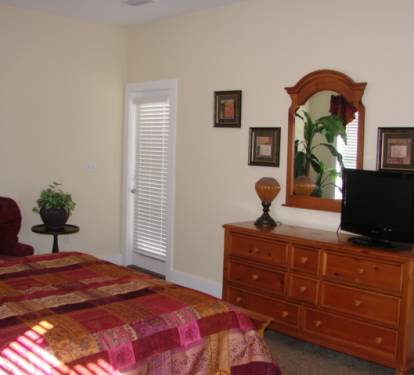 Second floor guest bedroom with queen bed has flat screen tv and attached bath