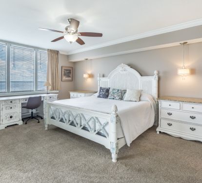 Master bed with granite top nightstands and work desk overlooking the bay.