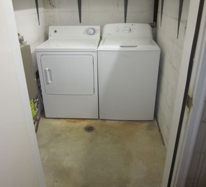 Storage room with lots of shelves and full sized washer and dryer.