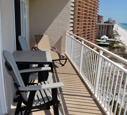 Balcony with 2 counter height chairs and a lounge chair