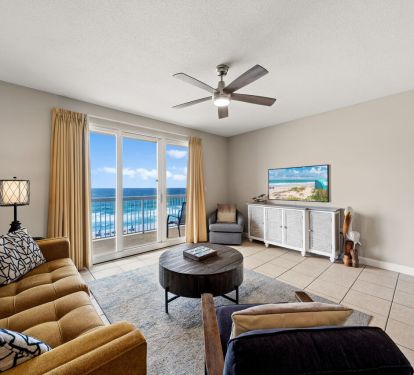 Bright Gulf-front living room with balcony access, coastal decor, and ocean views