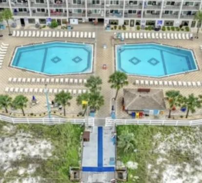 View of pool deck showing pools and tiki bar