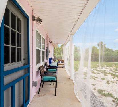 Covered back porch with screen door &amp; nautical lighting