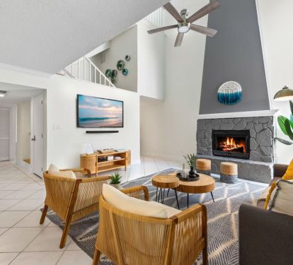 Cozy up at Seabreeze Villa ðŸ”¥ This inviting living room features a warm fireplace and coastal-inspired decor&mdash;perfect for relaxing after a day at the beach. Your seaside escape is just a booking away! ðŸŒ´âœ¨