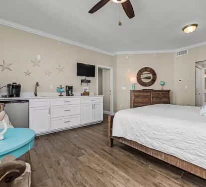 King bedroom suit, an en-suite bathroom, a kitchenette with mini-fridge, microwave, sink and quartz countertops, and a private balcony overlooking the island and the sound.