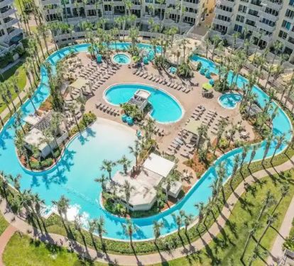 Aerial view of Lazy River, pool, and heated spas. Wristbands required to access.