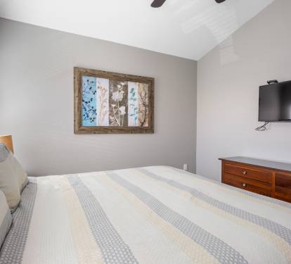 King suite has mounted flat screen tv and plenty of drawer space
