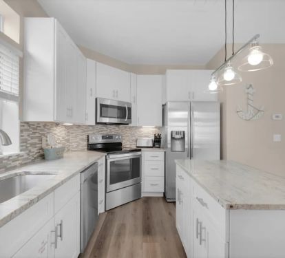 Sunkissed-15 kitchen features granite counters, stainless appliances and farm sink.
