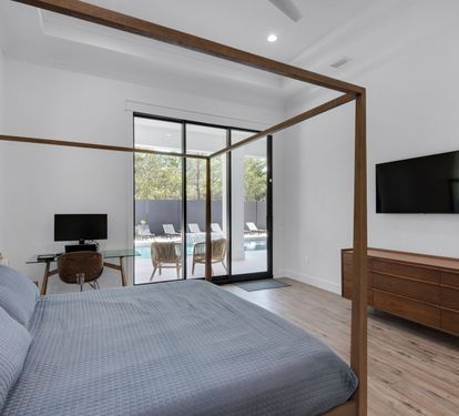 King Master bedroom with desk, and glass doors that lead you to the pool area.