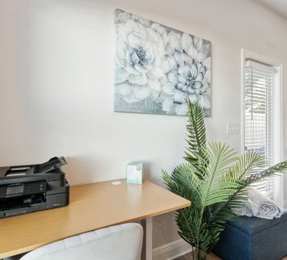 Dedicated workspace area with desk, chair, and printer perfect for remote work or quick tasks. 