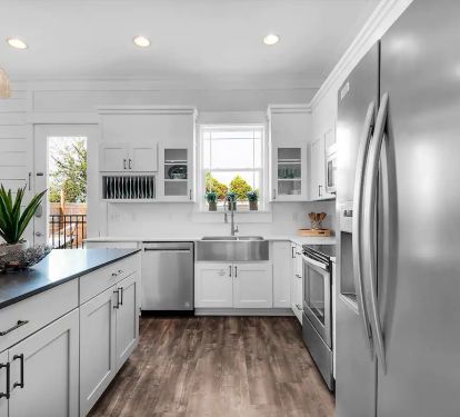 Freestyle-10 nouveau-chic kitchen featuring stainless appliances, apron sink, and granite island.