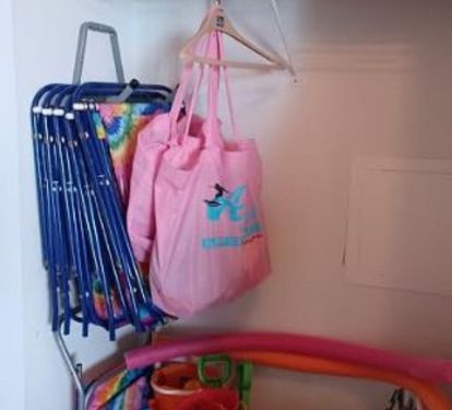Entryway closet featuring additional beach chairs and beach toys.