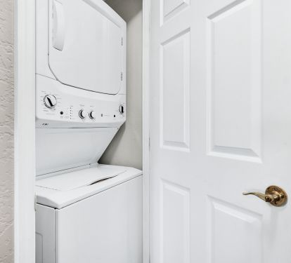 Laundry closet with stack washer and dryer.