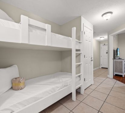 Built-in hallway bunk beds with bright tile floors and coastal style