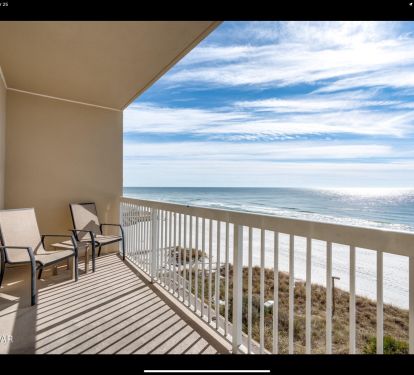Gulf-front balcony with seating, white sand beach below, and endless ocean views