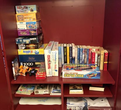 Entertainment cabinet with books, puzzles and games for your use.