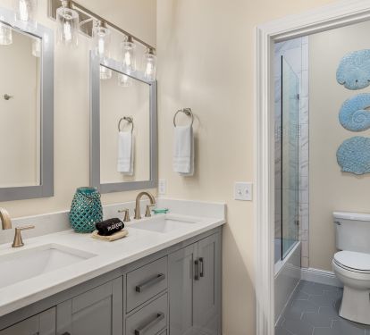 Bathroom has double vanity, newly tiled tub/shower