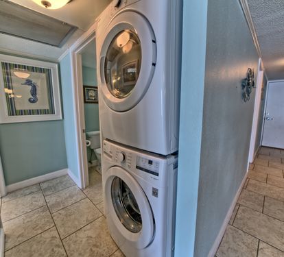 Full size stackable front load washer and dryer in hall