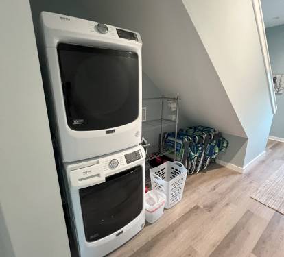 Washer, dryer, storage for beach gear, and chairs on bottom floor
