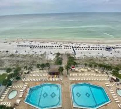 View of pool deck that shows both pools, kiddie pools Tiki bar