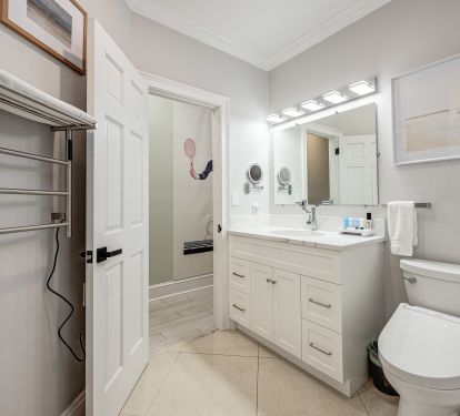 is beautifully remodeled bathroom features a sleek walk-in shower with modern finishes and a premium TOTO Washlet for added comfort.