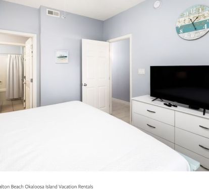 Bedroom with Smart TV and ample storage.