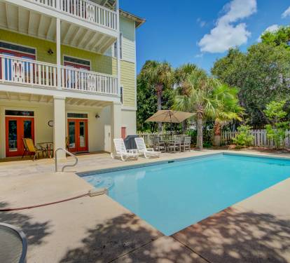 Private pool features multiple seating options, including an umbrella table 