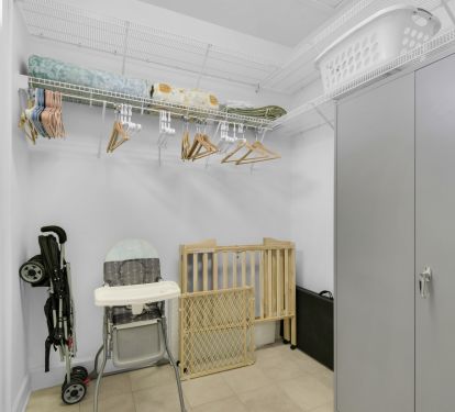 LARGE FOURTH BEDROOM CLOSET WITH STROLLER, HIGH CHAIR AND DELTA MINI CRIB