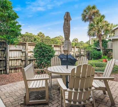 Condo's courtyard, with dining table and full-size gas grill