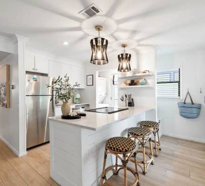 Open concept kitchen with washer dryer nook by back door 