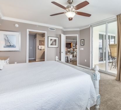Master bedroom with armoire enclosed TV and separate balcony access.
