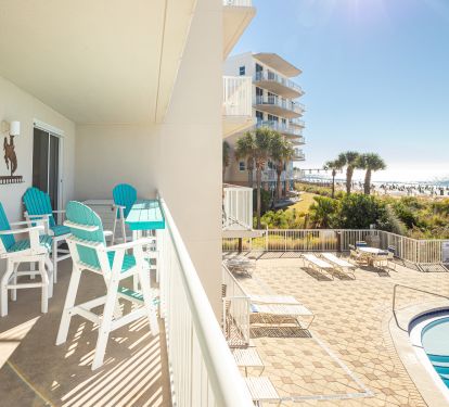 Spacious balcony overlooking swimming pool and beach views
