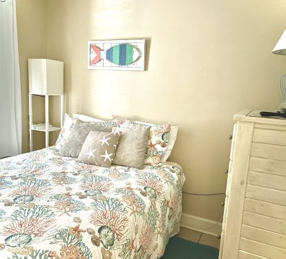 Queen bedroom with tall dresser and 32 inch TV