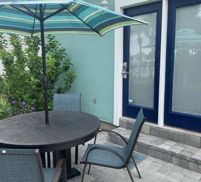 Rear patio is steps away from community pool and hot tub