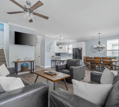 Large living room with TV; dining room and kitchen in background