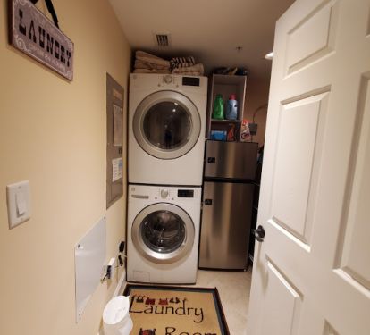 Laundry room stocked with detergent, softener, and dryer sheets.