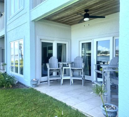 PATIO WITH TWO BAR HEIGHT CHAIRS &amp; TABLE SETS AND ONE STOOL BEHIND EACH TABLE 