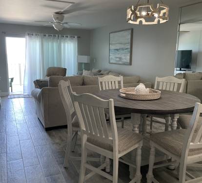 View from Dining Area to Living Area with Sliders to Balcony