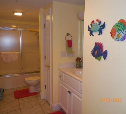 FROM THE GUEST BEDROOM STEP INTO THE TROPICALLY DECORATED BATH