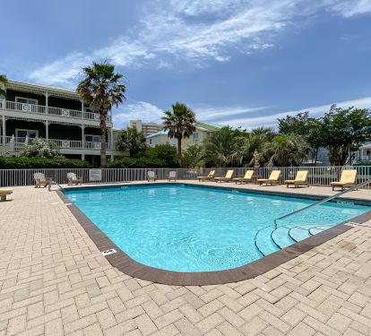 Large Community Pool with Lounge chairs and umbrellas.