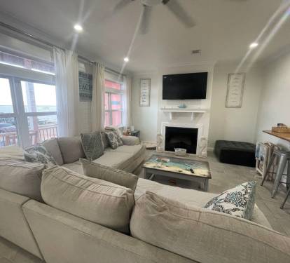 Spacious living area with large comfy sectional with TV overlooking the marina