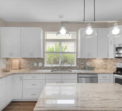Sunkissed-13 kitchen features granite counters, stainless appliances and farm sink.