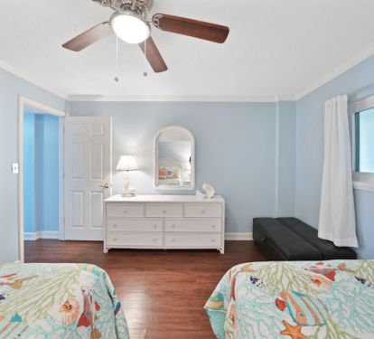 Two queen beds and a single ottoman in the second bedroom